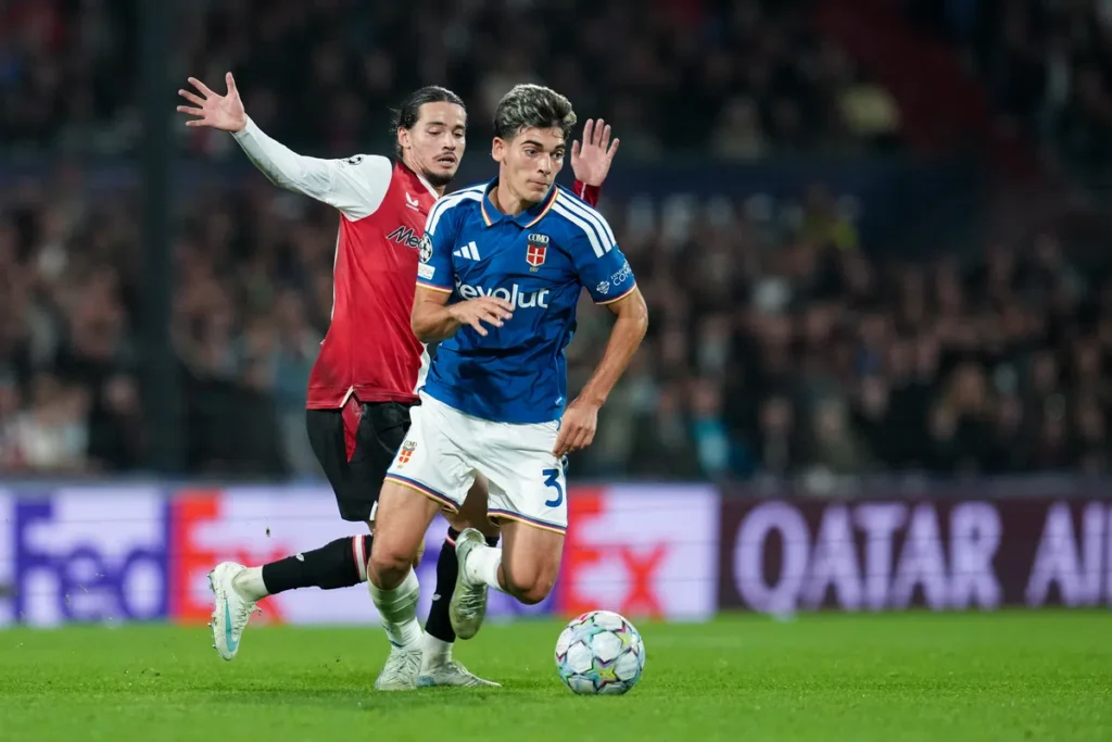 Spelers van Como en Feyenoord in duel tijdens een voetbalwedstrijd.