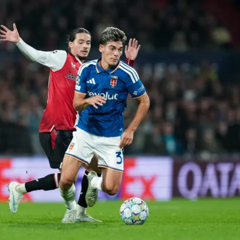Spelers van Como en Feyenoord in duel tijdens een voetbalwedstrijd.