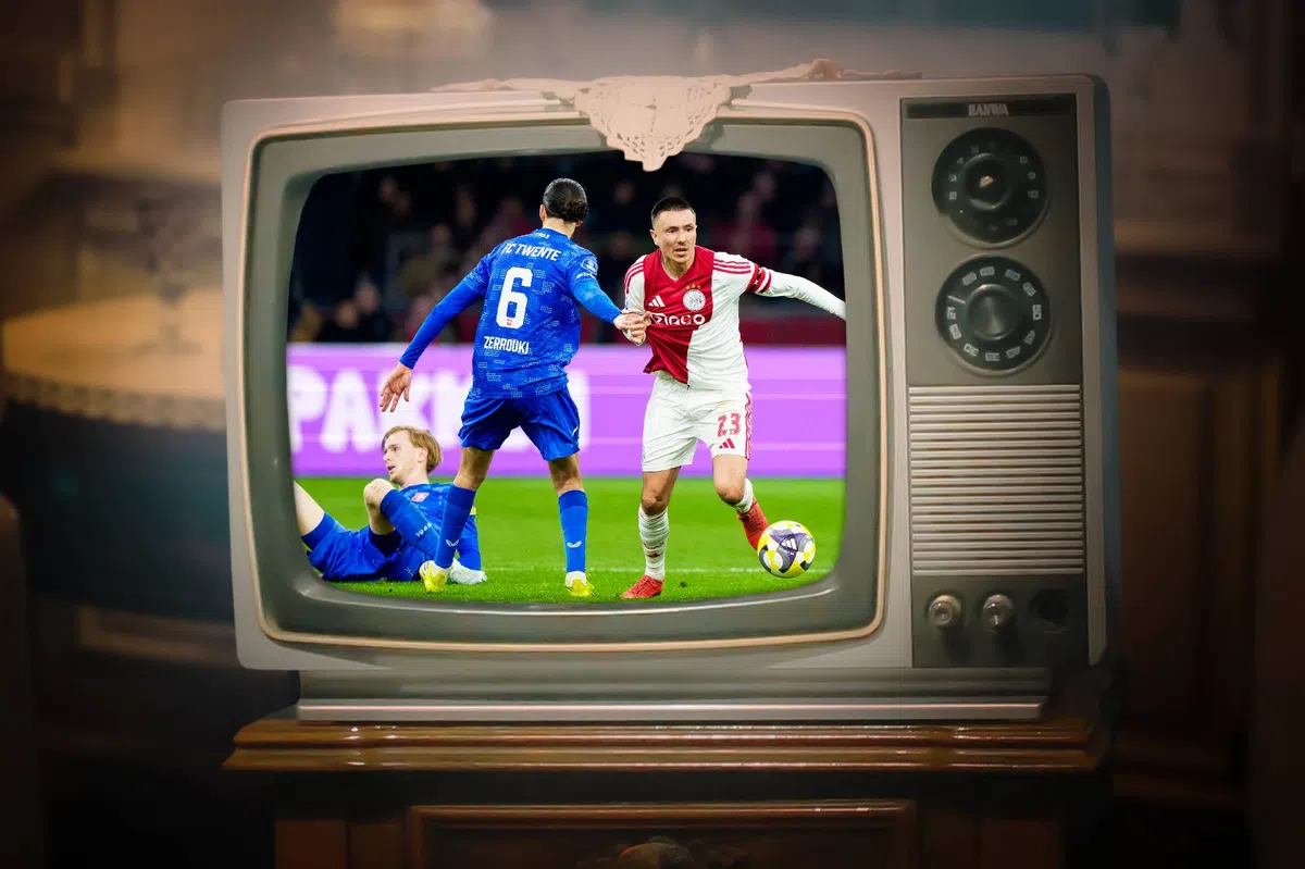 Oude televisie waarop een voetbalwedstrijd te zien is, met spelers van FC Twente en Ajax in beeld.
