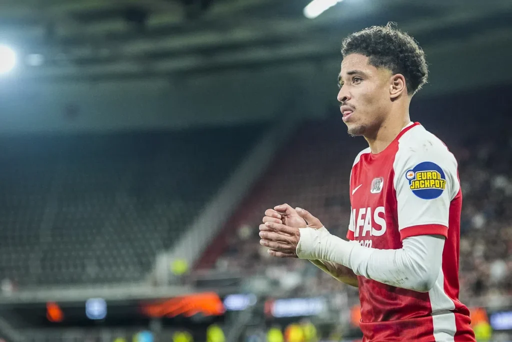 AZ-speler in rood-wit tenue op het veld tijdens een wedstrijd.