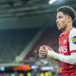 AZ-speler in rood-wit tenue op het veld tijdens een wedstrijd.