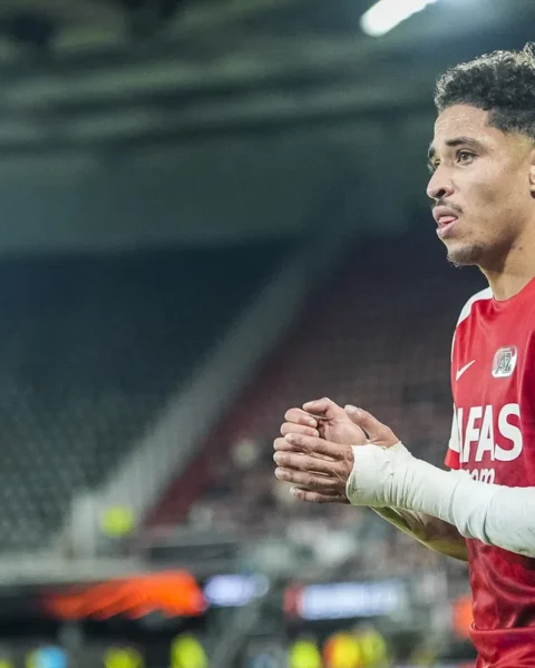AZ-speler in rood-wit tenue op het veld tijdens een wedstrijd.