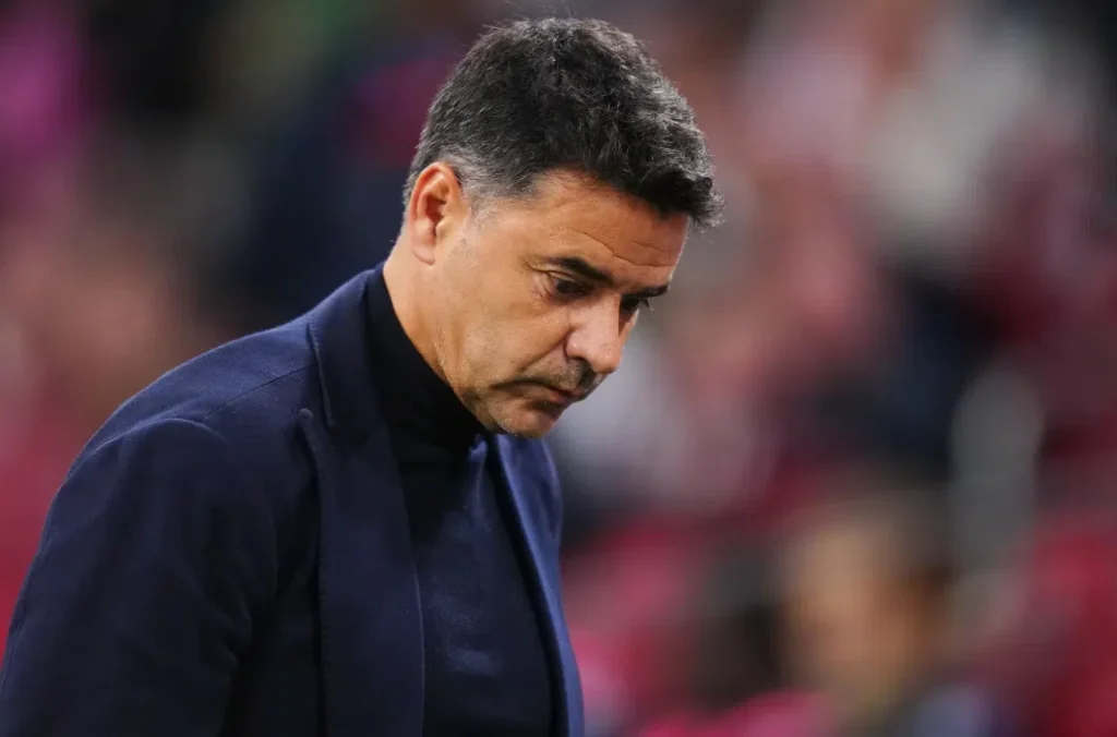 Míchel Sánchez kijkt somber langs de zijlijn tijdens een wedstrijd.