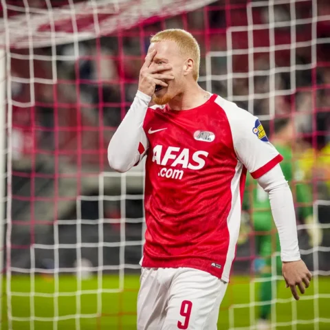 AZ-speler in rood-wit shirt bij het doel na een gemiste kans.