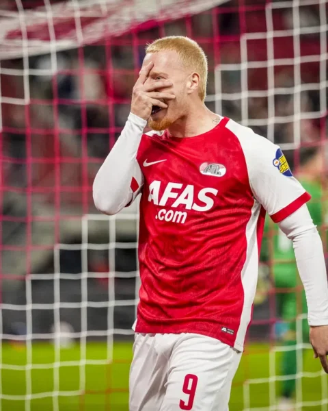 AZ-speler in rood-wit shirt bij het doel na een gemiste kans.