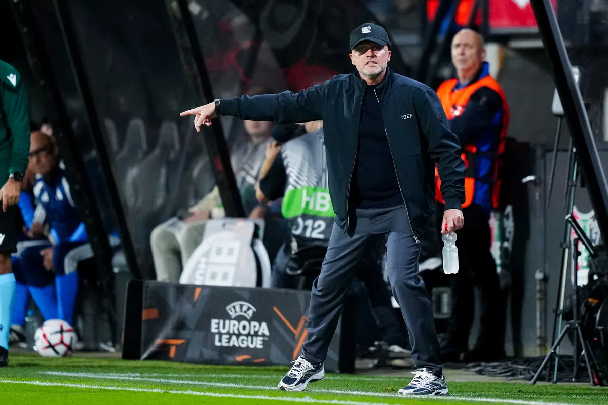 Dick Schreuder wijst langs de zijlijn tijdens een Europa League-wedstrijd.