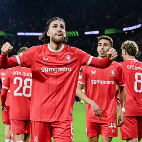 FC Twente-spelers vieren een doelpunt op het veld in een vol stadion.
