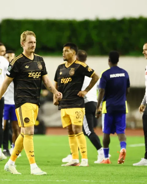 Spelers van Ajax en Hajduk Split op het veld tijdens een onderbreking van de wedstrijd.