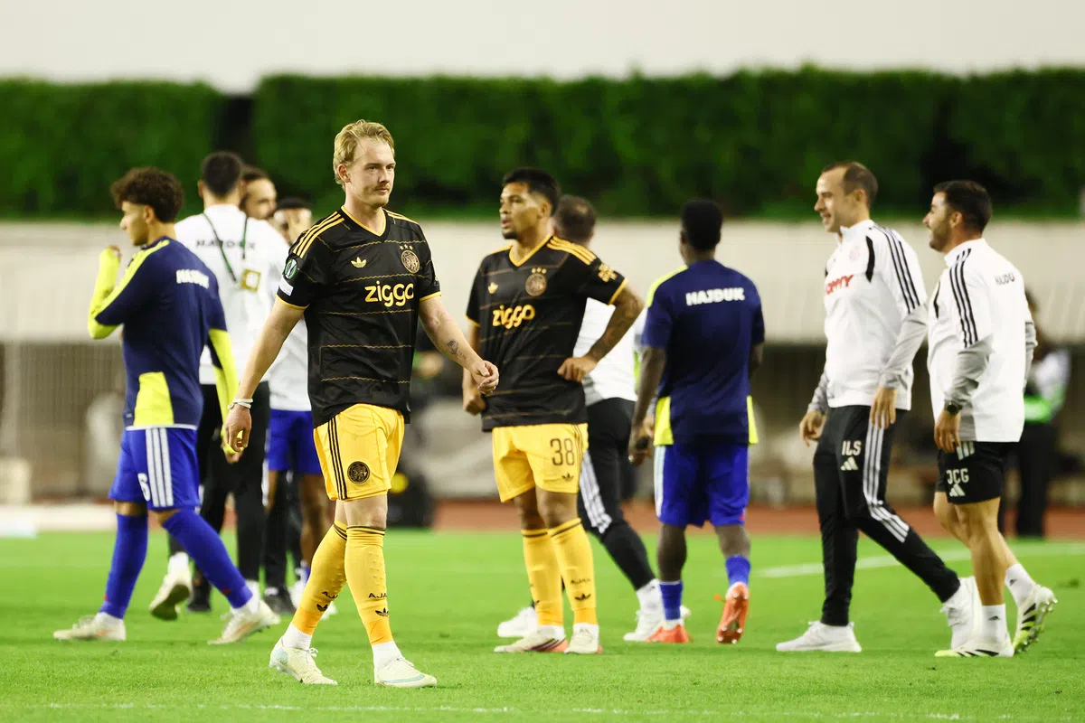 Spelers van Ajax en Hajduk Split op het veld tijdens een onderbreking van de wedstrijd.