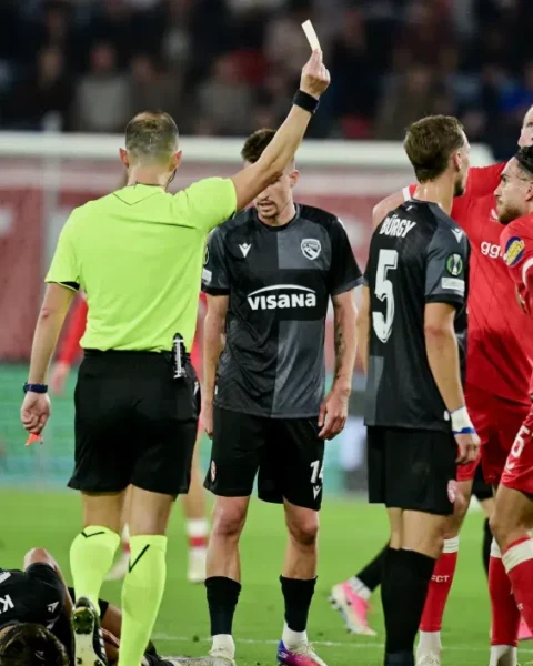Scheidsrechter toont een rode kaart tijdens FC Twente-FC Thun, terwijl spelers van beide teams rond hem staan.