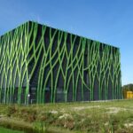 Een datacentergebouw met groene gevelbekleding in een open landschap.