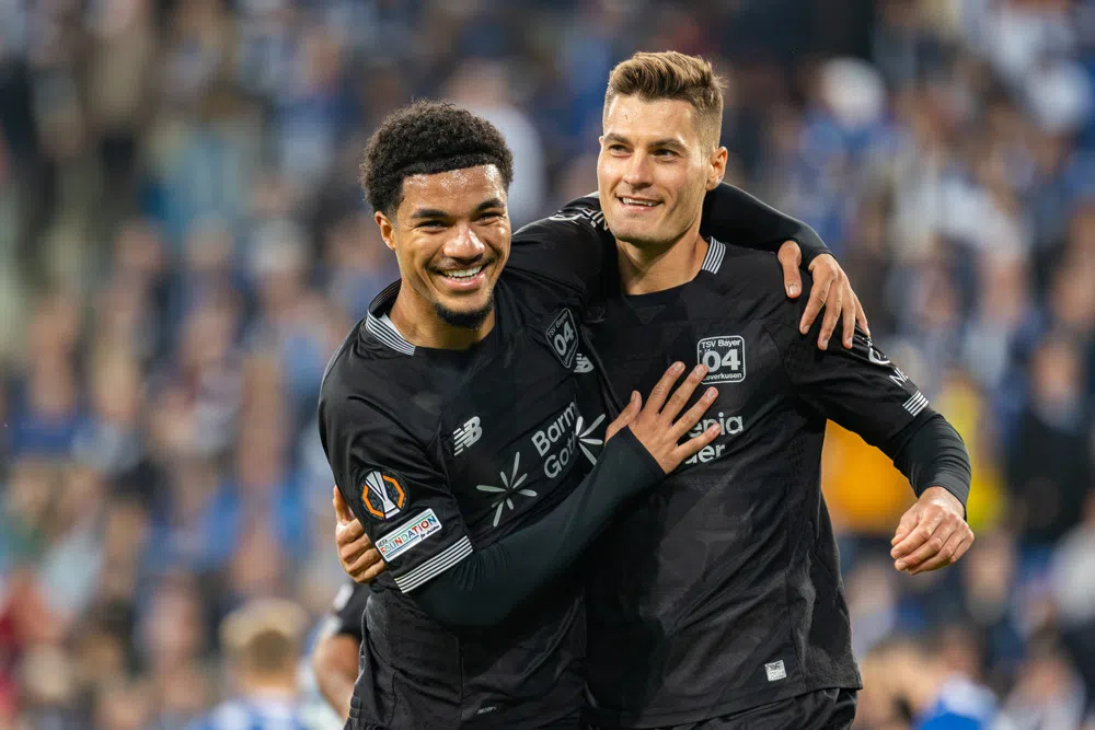 Malik Tillman viert een doelpunt samen met een ploeggenoot van Bayer Leverkusen.
