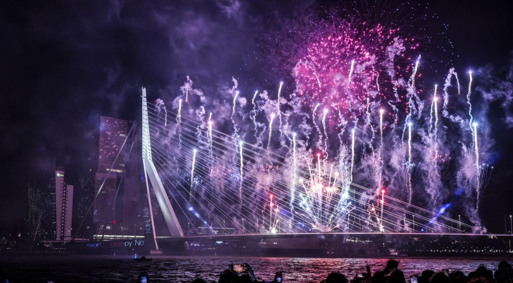 Vuurwerk boven de Erasmusbrug in Rotterdam bij nacht.
