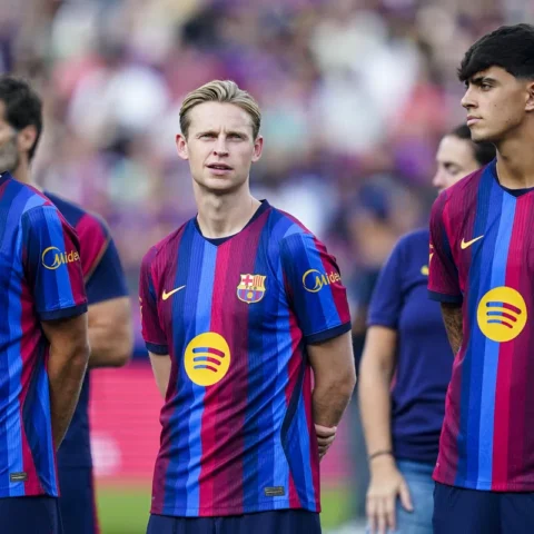 Frenkie de Jong staat tussen Barcelona-teamgenoten op het veld in het stadion.