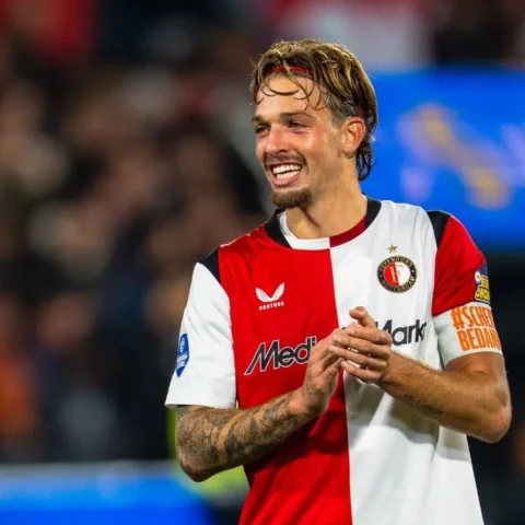 Luciano Valente in het shirt van Feyenoord tijdens een wedstrijd, lachend op het veld.