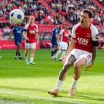 AZ-speler juicht na een actie in het strafschopgebied tijdens een wedstrijd.