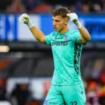 SC Heerenveen-keeper in groen tenue juicht in het stadion met opgeheven vuisten.
