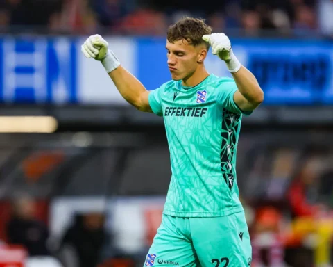SC Heerenveen-keeper in groen tenue juicht in het stadion met opgeheven vuisten.