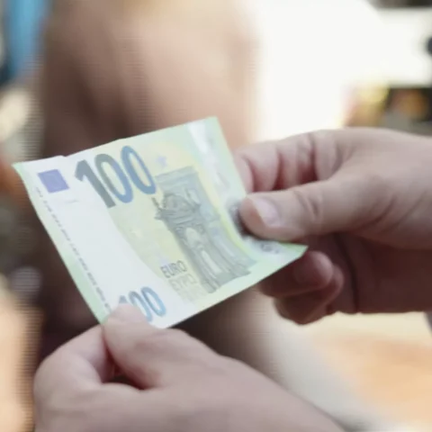Handen houden een 100-eurobiljet vast.
