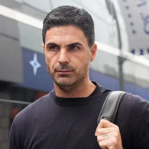 Mikel Arteta loopt buiten een Arsenal-locatie met een tas over zijn schouder.