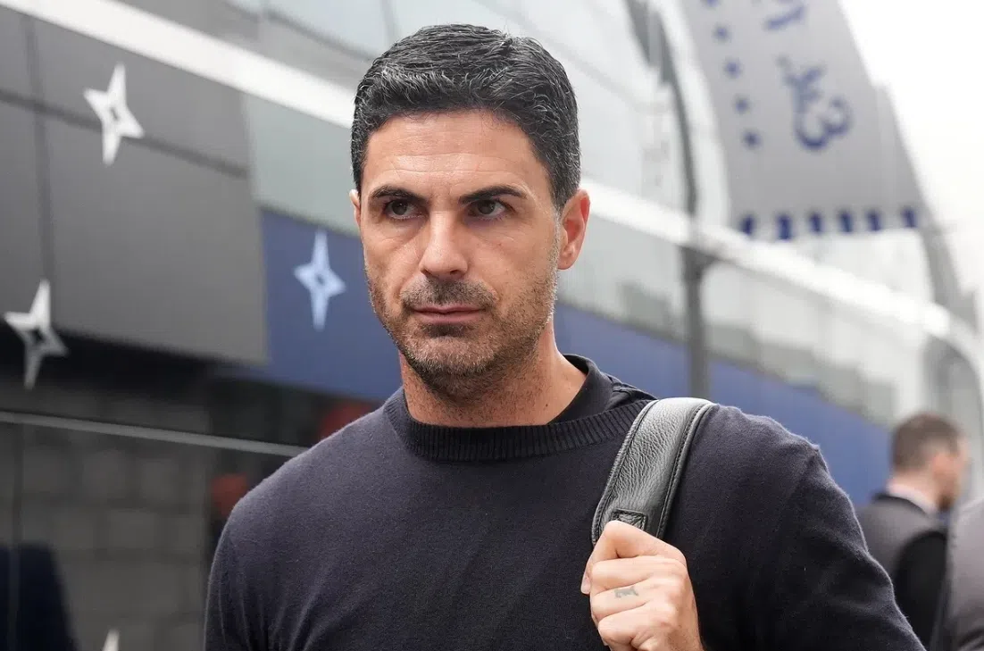Mikel Arteta loopt buiten een Arsenal-locatie met een tas over zijn schouder.