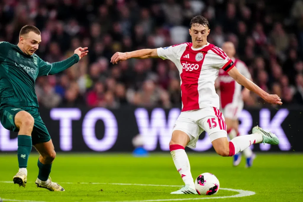 Youri Baas van Ajax in duel met een tegenstander tijdens een voetbalwedstrijd.