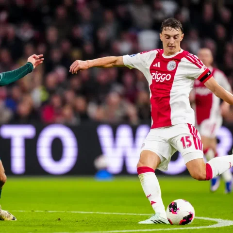 Youri Baas van Ajax in duel met een tegenstander tijdens een voetbalwedstrijd.