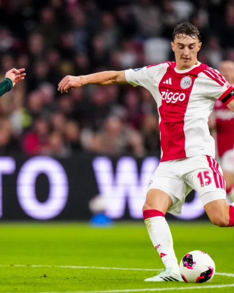 Youri Baas van Ajax in duel met een tegenstander tijdens een voetbalwedstrijd.