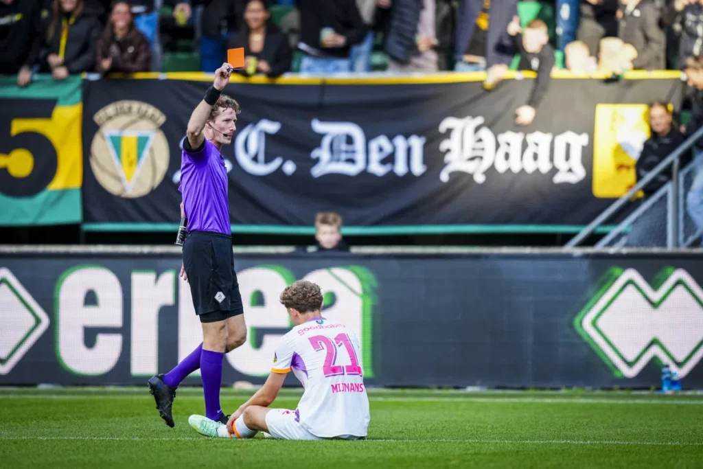 Scheidsrechter toont een rode kaart aan PSV-speler Sven Mijnans op het veld bij ADO Den Haag.