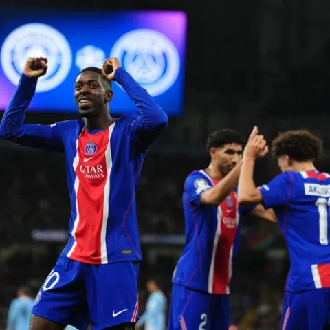 Ousmane Dembélé viert een PSG-doelpunt met opgeheven armen tijdens een wedstrijd.
