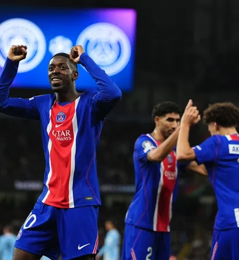 Ousmane Dembélé viert een PSG-doelpunt met opgeheven armen tijdens een wedstrijd.
