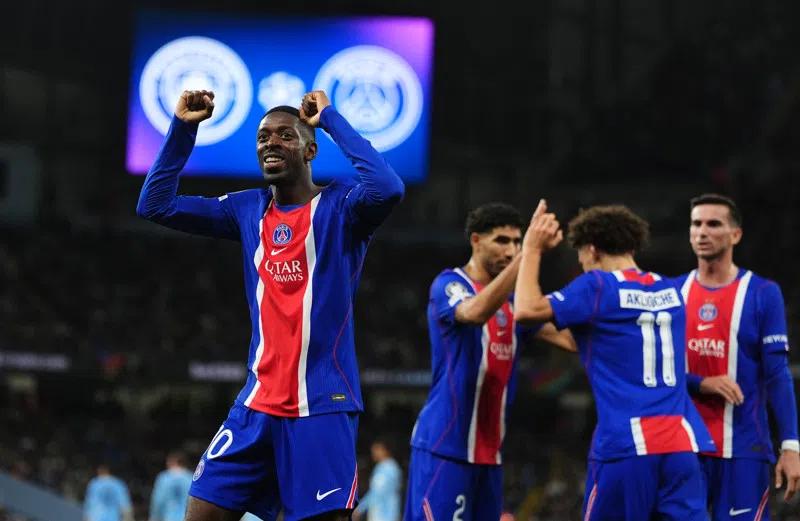 Ousmane Dembélé viert een PSG-doelpunt met opgeheven armen tijdens een wedstrijd.