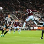 Spelers van Aston Villa en Newcastle United springen voor de bal tijdens een Premier League-wedstrijd.
