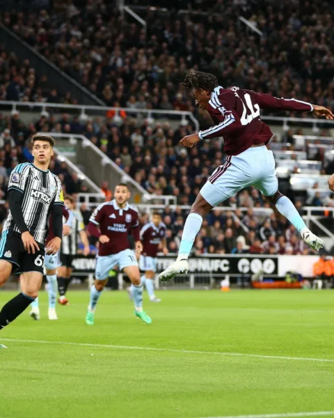 Spelers van Aston Villa en Newcastle United springen voor de bal tijdens een Premier League-wedstrijd.