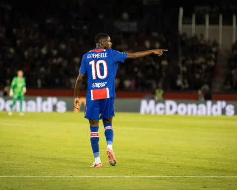 Ousmane Dembélé in een PSG-shirt wijst op het veld tijdens een wedstrijd.