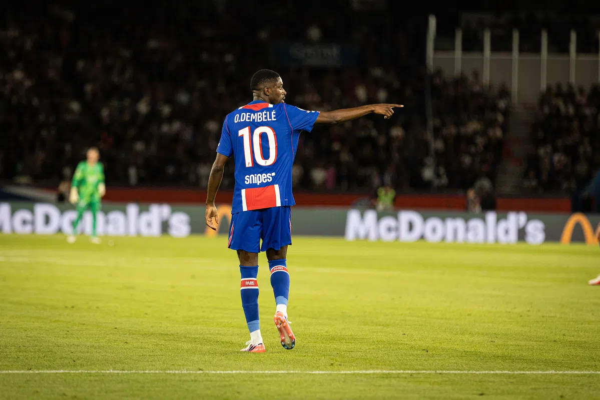 Ousmane Dembélé in een PSG-shirt wijst op het veld tijdens een wedstrijd.
