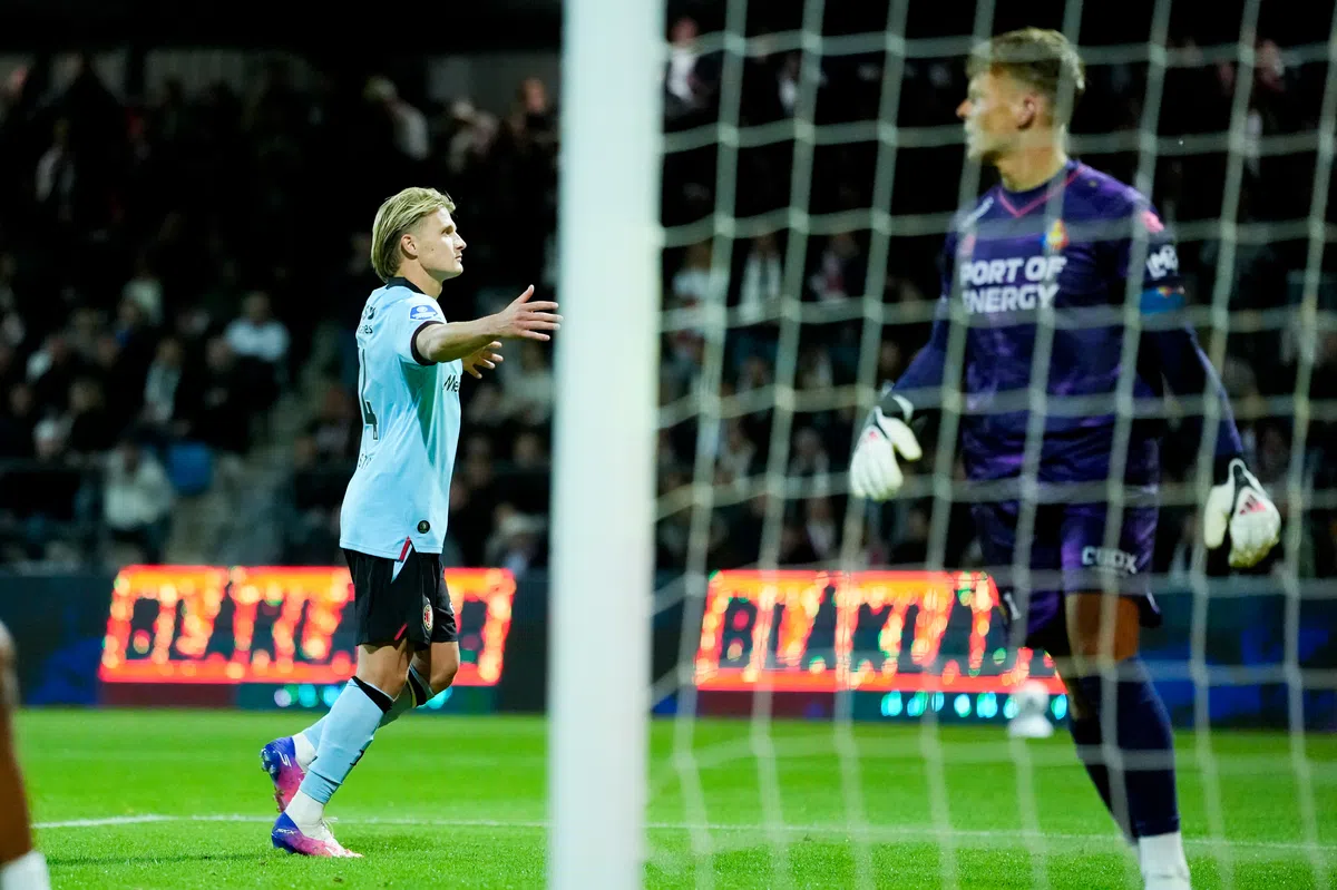 Sem Steijn in lichtblauw shirt juicht naast het doel tijdens een voetbalwedstrijd, met de keeper in paars op de achtergrond.