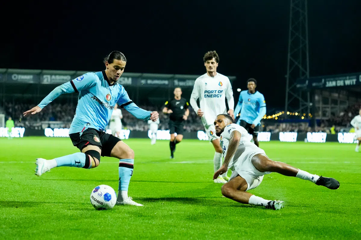 Voetballers van Feyenoord en Telstar in duel om de bal tijdens een wedstrijd.