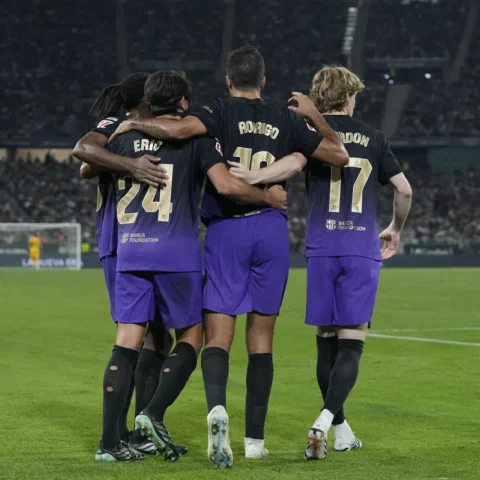 FC Barcelona-spelers staan omhelsd op het veld in een stadion.
