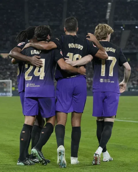 FC Barcelona-spelers staan omhelsd op het veld in een stadion.