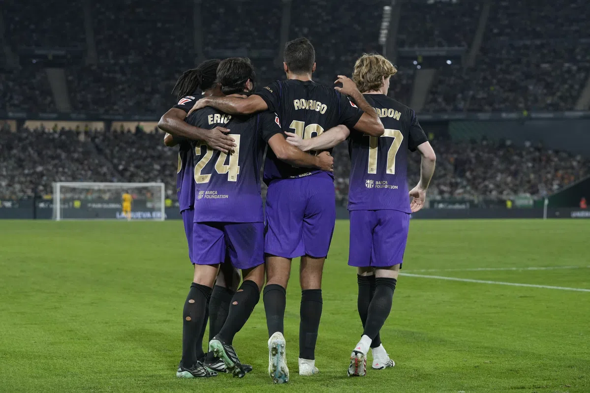FC Barcelona-spelers staan omhelsd op het veld in een stadion.