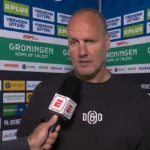 Dick Lukkien spreekt voor een sponsorwand na de wedstrijd van FC Groningen.