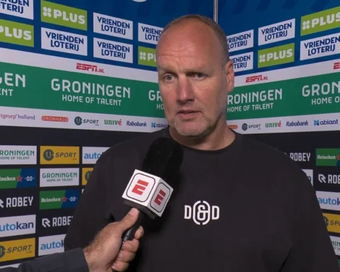 Dick Lukkien spreekt voor een sponsorwand na de wedstrijd van FC Groningen.