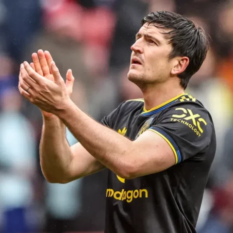 Lisandro Martínez applauds on the pitch in a Manchester United away kit.