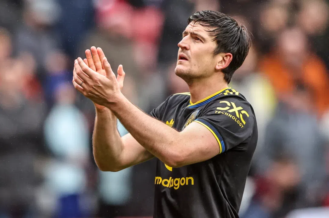 Lisandro Martínez applauds on the pitch in a Manchester United away kit.