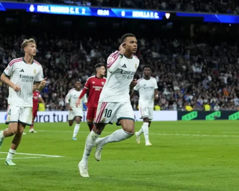 Kylian Mbappé juicht op het veld tijdens een wedstrijd van Real Madrid tegen Sevilla.