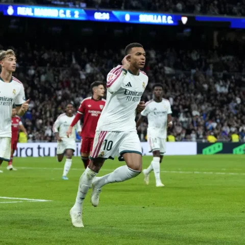 Kylian Mbappé juicht op het veld tijdens een wedstrijd van Real Madrid tegen Sevilla.