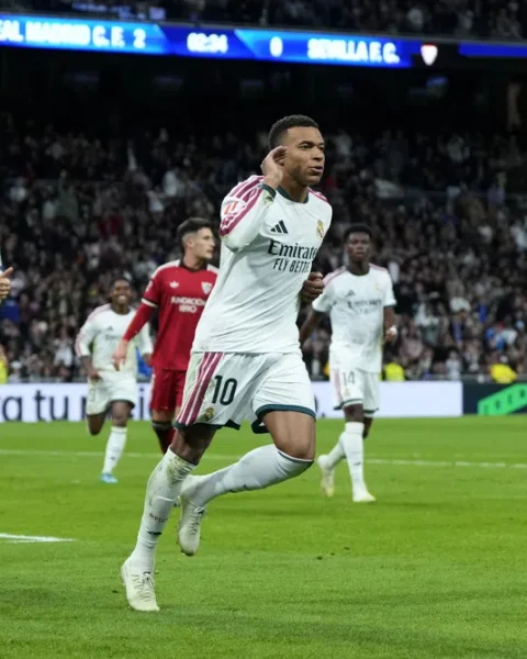 Kylian Mbappé juicht op het veld tijdens een wedstrijd van Real Madrid tegen Sevilla.