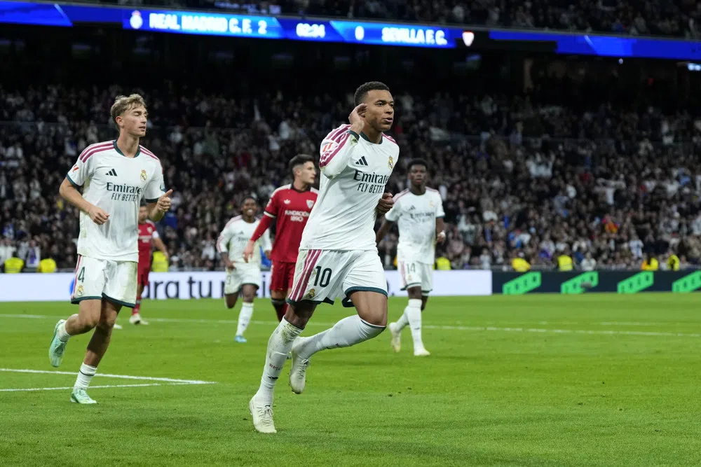 Kylian Mbappé juicht op het veld tijdens een wedstrijd van Real Madrid tegen Sevilla.
