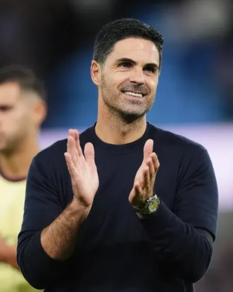 Mikel Arteta applauds on the touchline during a football match.